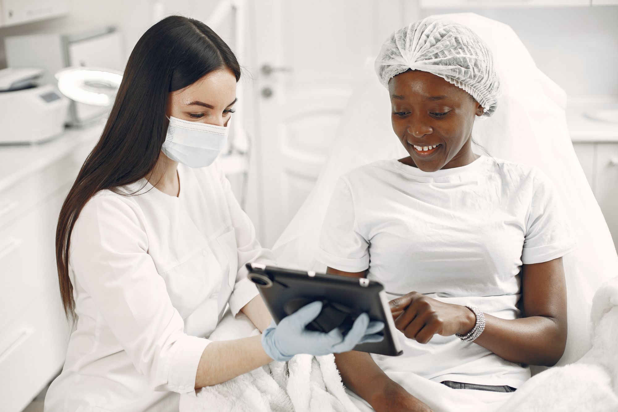 A dermatologist and patient reviewing images on a tablet