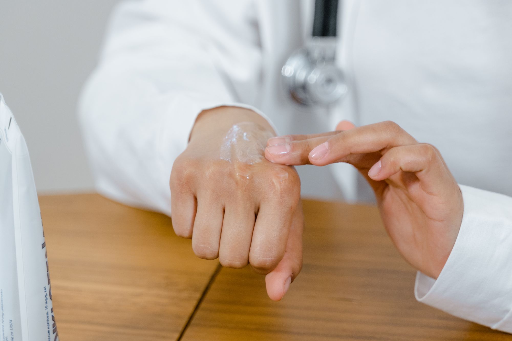 A clinician applying cream to the back of a patient's hand