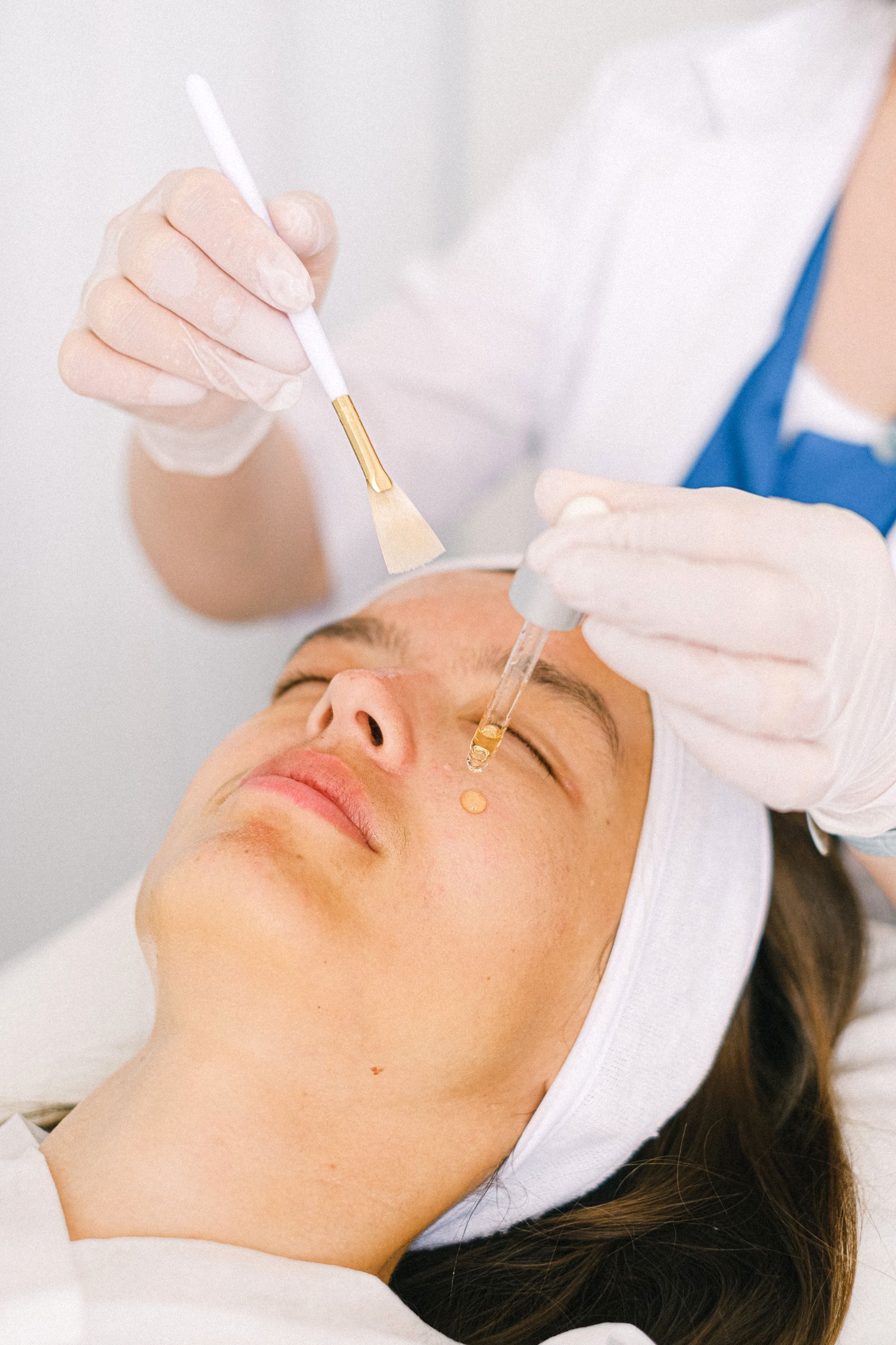 A clinician brushing a treatment onto a patient's face