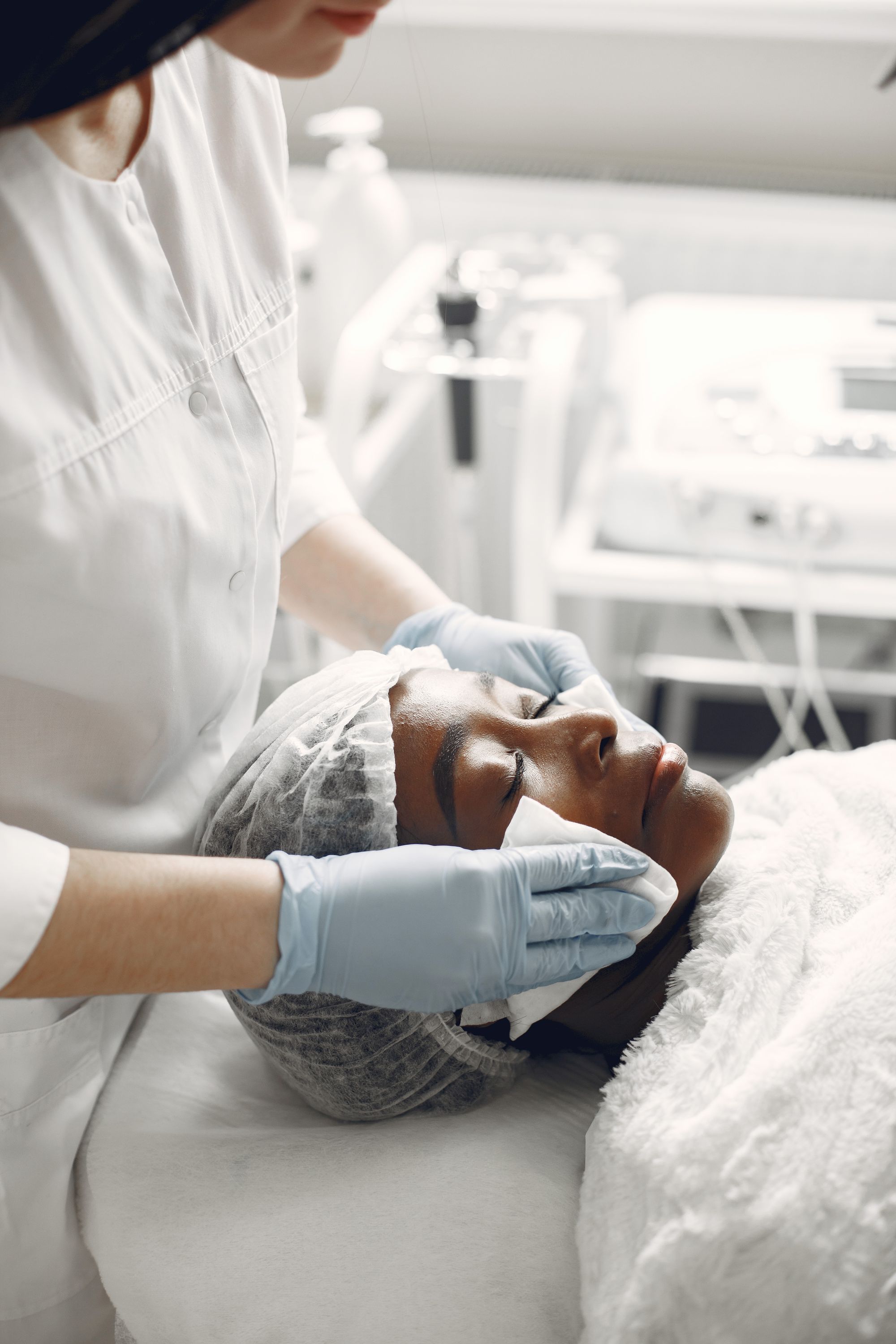 An esthetician giving a facial to a relaxed client