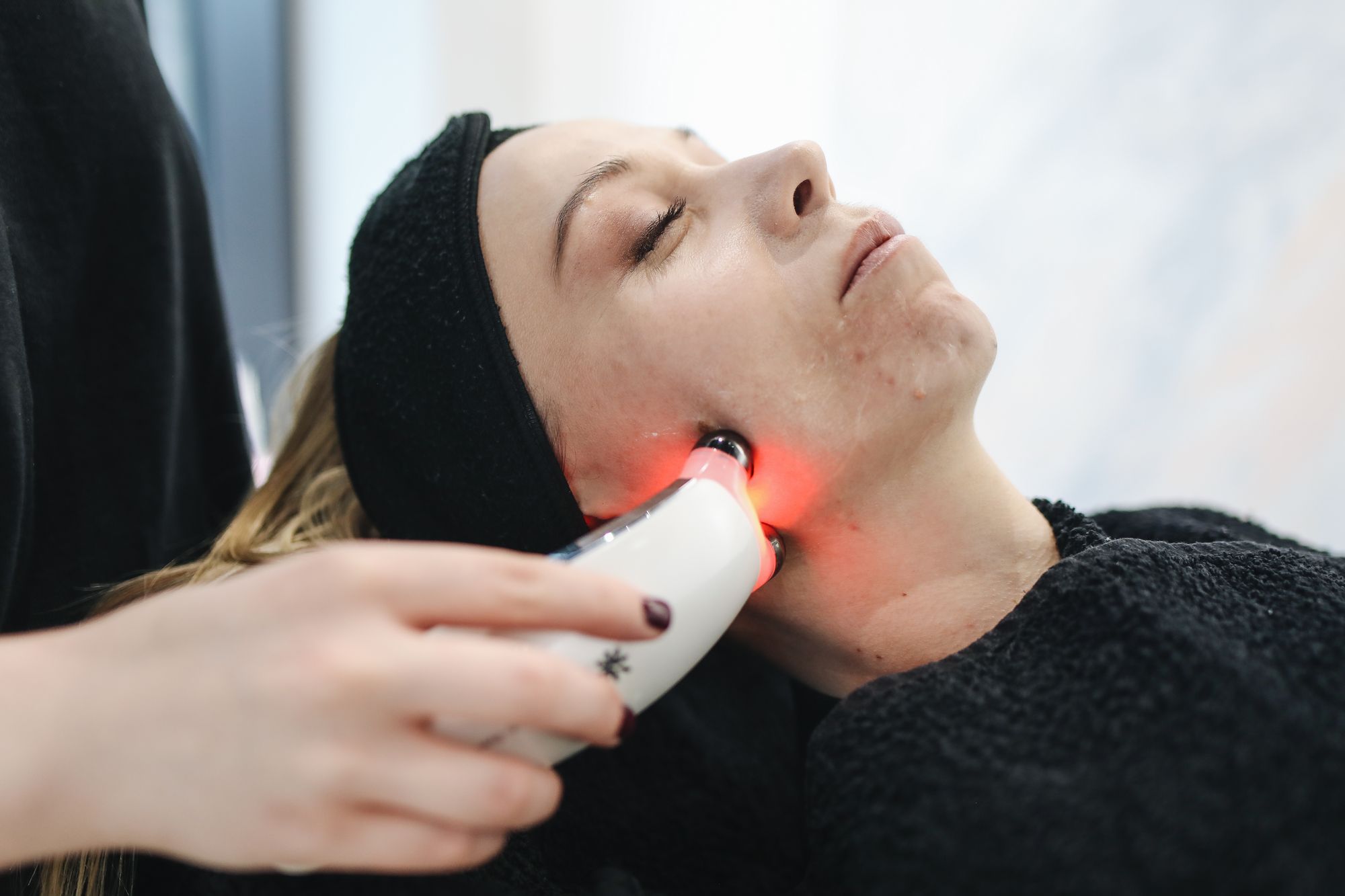A light-based device on a patient's jaw in a dim treatment room