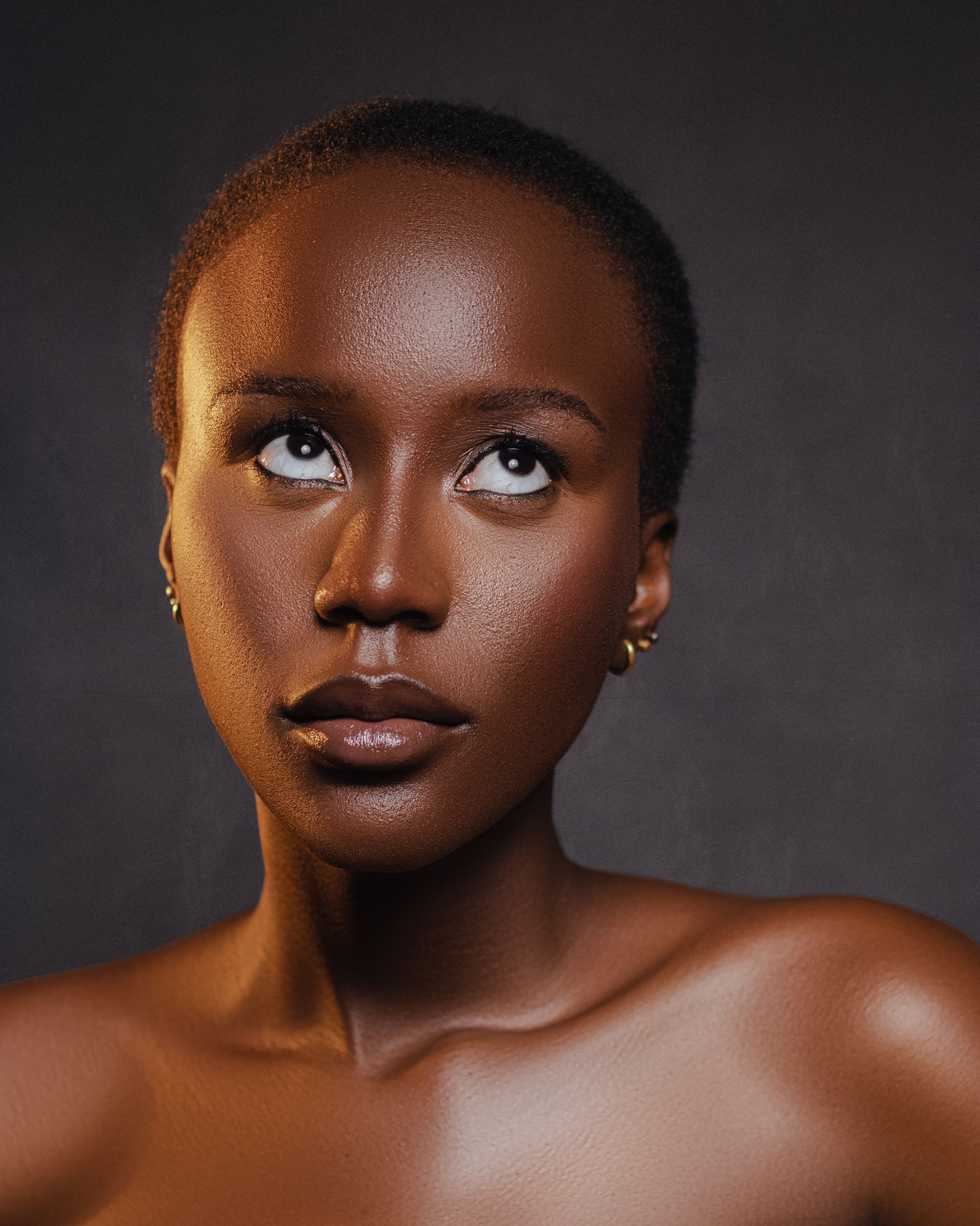 Portrait of a woman with glowing skin looking upward